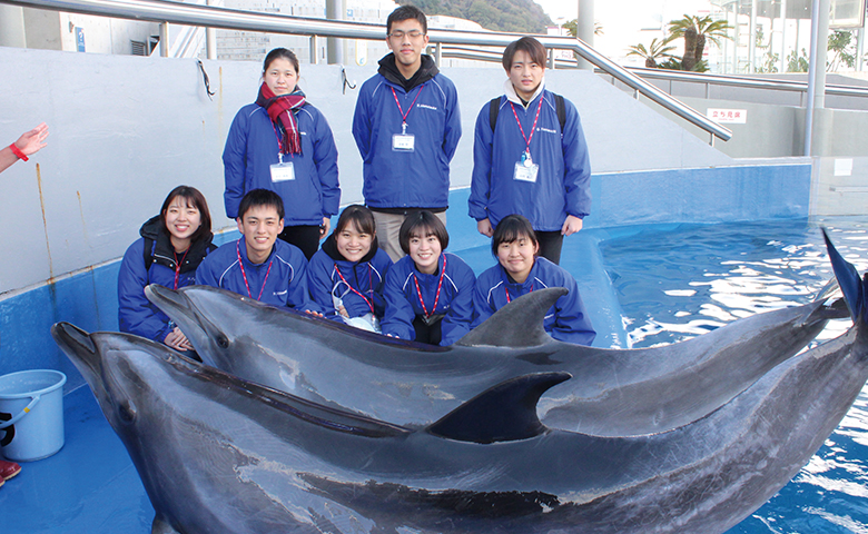 イルカと一緒に並ぶ学生たち